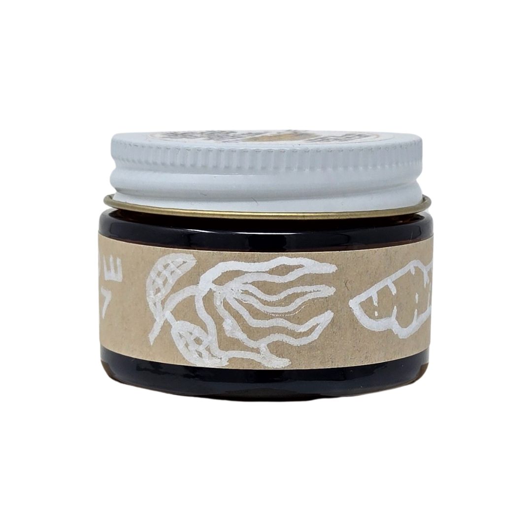 Hand-made herbal medicinal balm with a hand-drawl label of ginger and ylang-ylang essential oils in an amber glass jar. 1oz jar