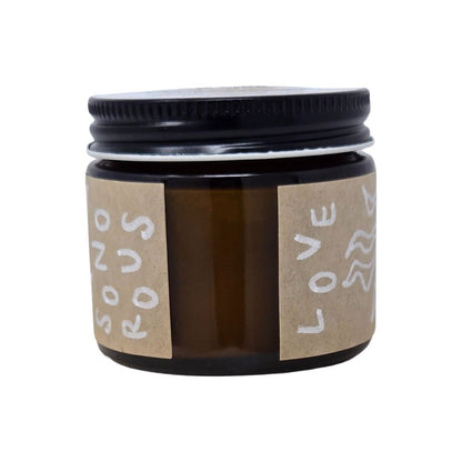 Amber Jar of herbal balm with a black lid and brown label, hand-drawn Sonorous Love brand image on a white background.